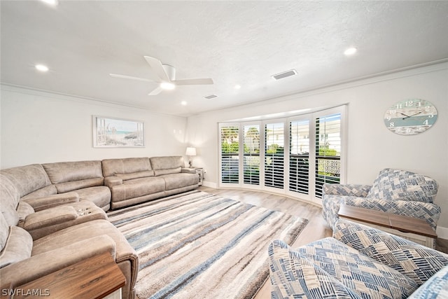 living room featuring light hardwood / wood-style flooring, crown molding, and ceiling fan