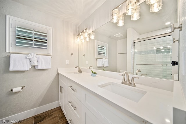 bathroom featuring hardwood / wood-style floors, vanity with extensive cabinet space, and dual sinks