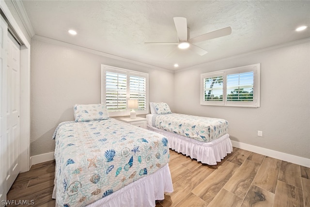 bedroom with a closet, ceiling fan, light hardwood / wood-style floors, and crown molding