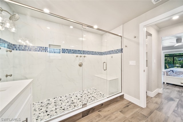 bathroom with wood-type flooring, ceiling fan, a shower with shower door, and crown molding