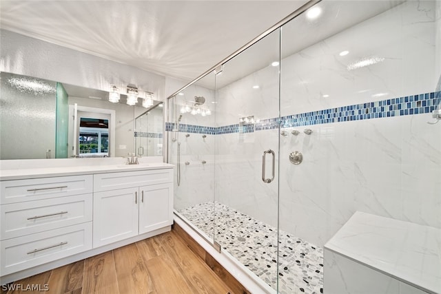 bathroom with walk in shower, vanity, and hardwood / wood-style floors