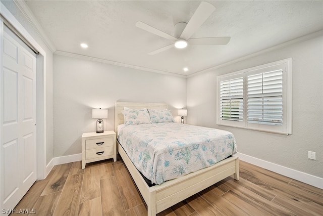 bedroom with hardwood / wood-style floors, a closet, ceiling fan, and crown molding