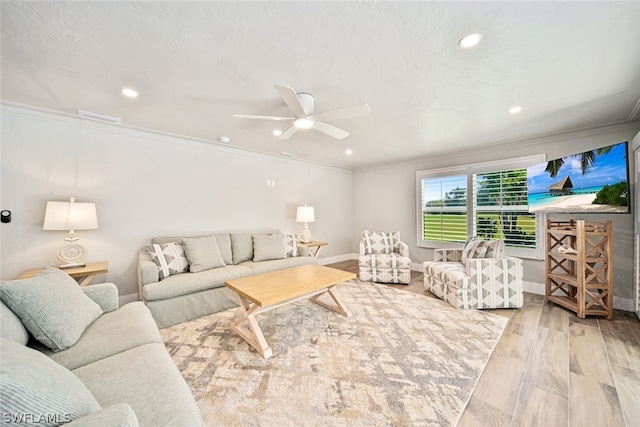 living room featuring hardwood / wood-style floors, ceiling fan, and crown molding