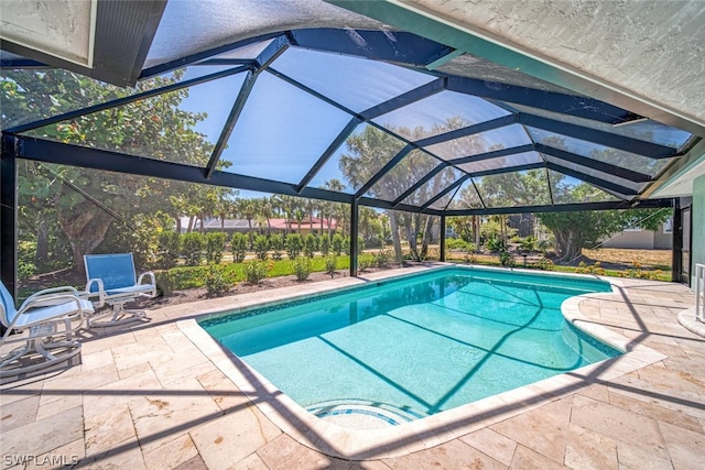 view of swimming pool featuring glass enclosure and a patio area