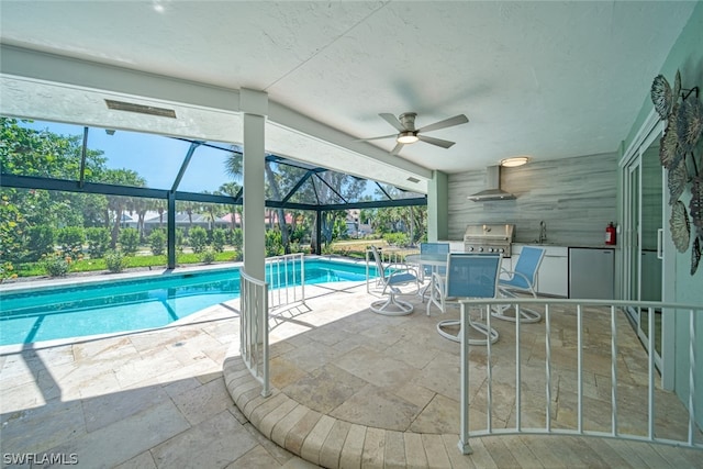 view of swimming pool featuring a grill, ceiling fan, a lanai, a patio, and sink