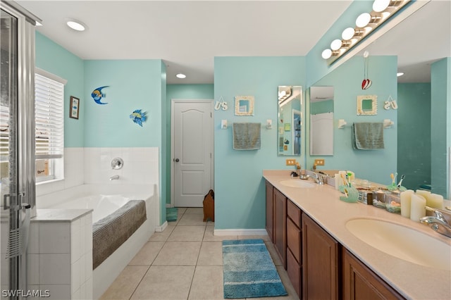 bathroom with tile floors, dual vanity, and tiled bath