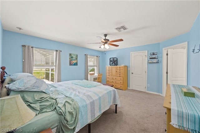 carpeted bedroom with multiple windows and ceiling fan