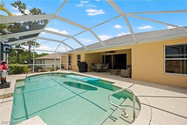 view of pool featuring ceiling fan, glass enclosure, and a patio