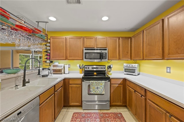 kitchen with sink, light tile floors, and stainless steel appliances