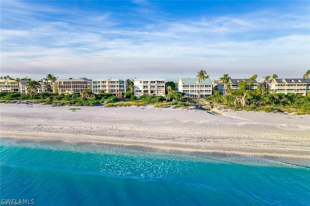 bird's eye view with a water view and a beach view