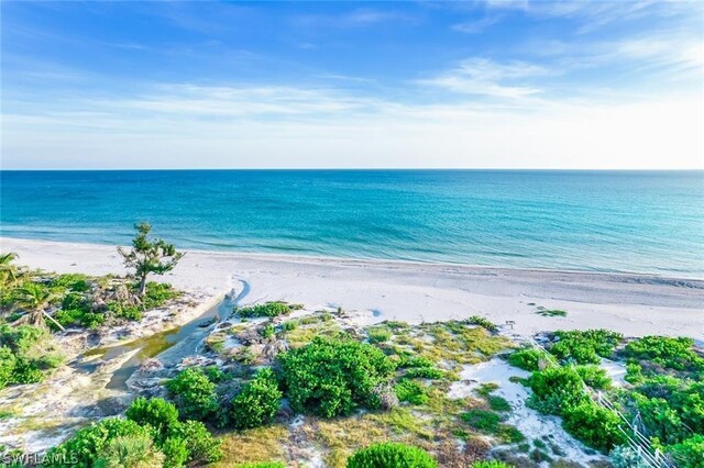 drone / aerial view featuring a water view and a view of the beach