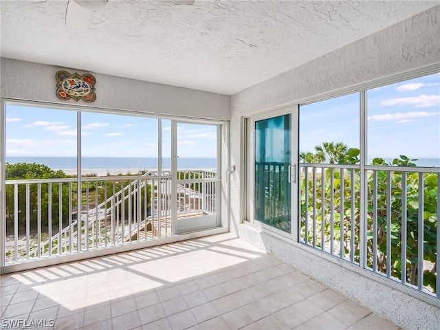 unfurnished sunroom featuring a water view