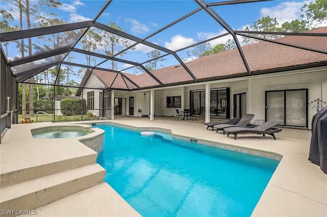 view of pool featuring a patio, glass enclosure, and an in ground hot tub