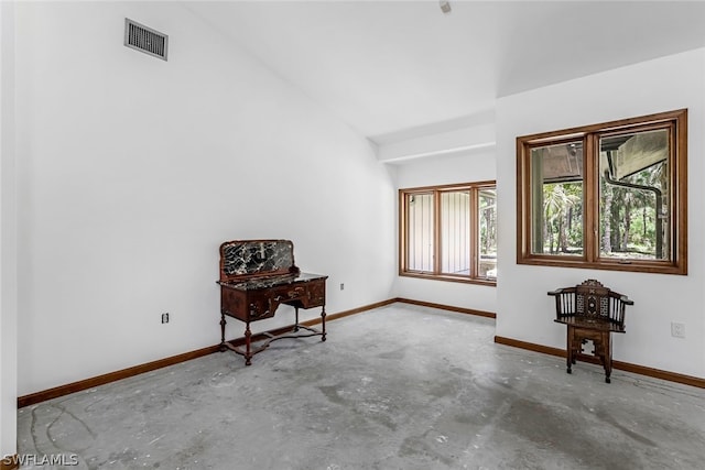 unfurnished room featuring concrete floors and lofted ceiling