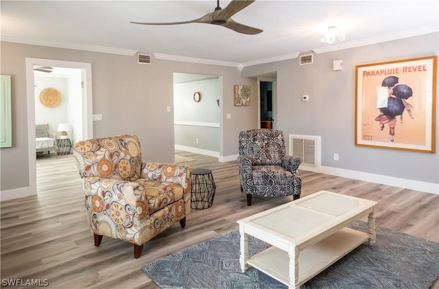 living room featuring ceiling fan, ornamental molding, and hardwood / wood-style flooring