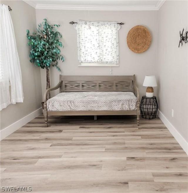 bedroom with light hardwood / wood-style floors and ornamental molding