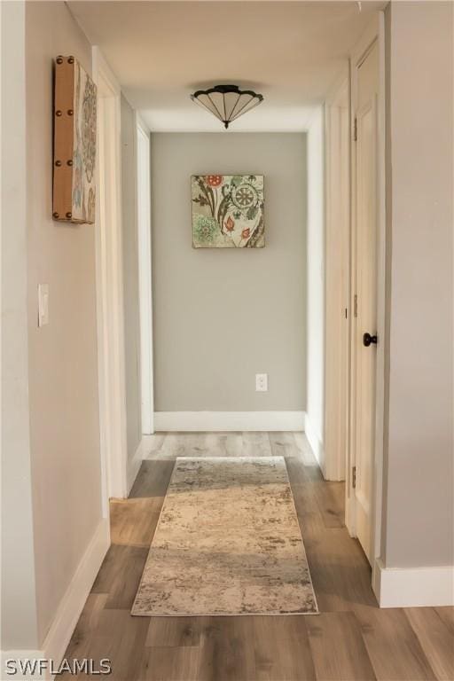 hallway with hardwood / wood-style flooring