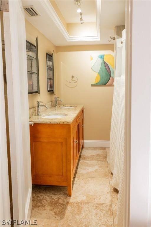 bathroom with vanity and a tray ceiling