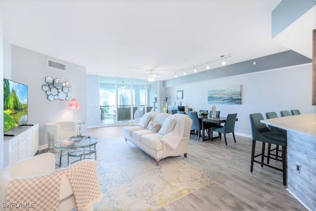 living room with light hardwood / wood-style flooring and ceiling fan