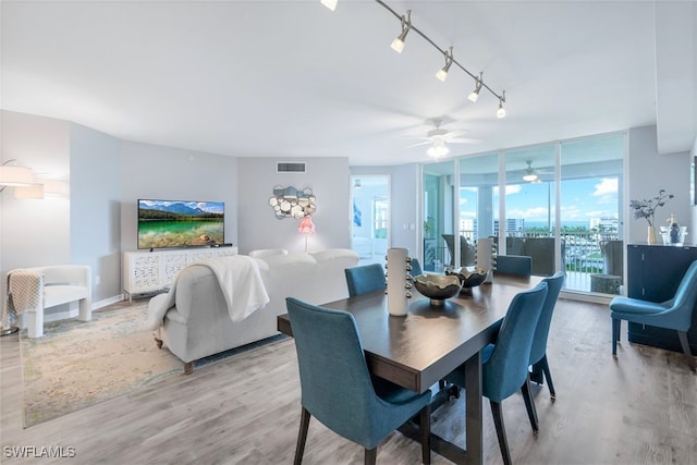 dining area featuring a wall of windows, track lighting, light hardwood / wood-style floors, and ceiling fan