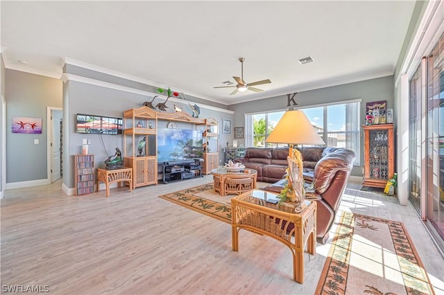 living area with light wood-type flooring, a ceiling fan, visible vents, and crown molding