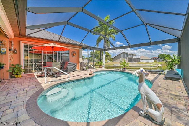 outdoor pool featuring glass enclosure and a patio