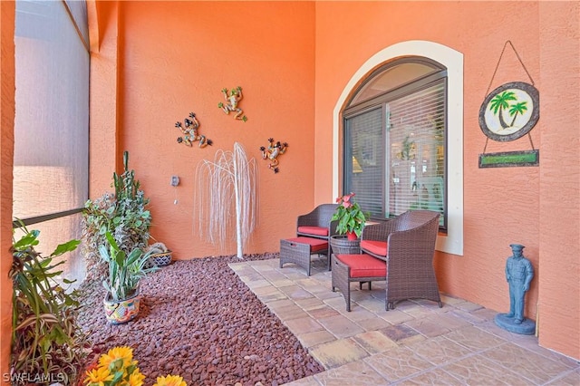 view of exterior entry with a patio area and stucco siding