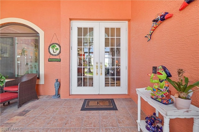 entrance to property featuring stucco siding, a patio area, and french doors