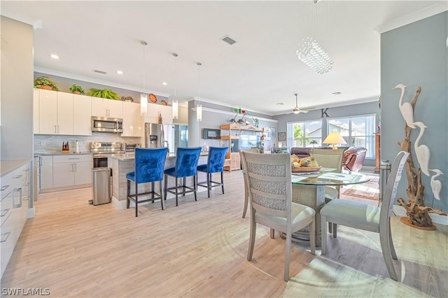 dining space with crown molding, recessed lighting, visible vents, light wood-style flooring, and ceiling fan