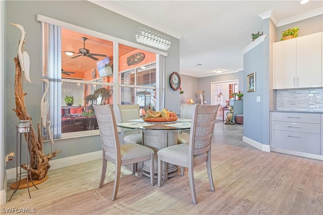 dining room featuring light wood finished floors, a wealth of natural light, and crown molding