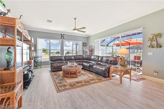 living room with a ceiling fan, wood finished floors, visible vents, and crown molding