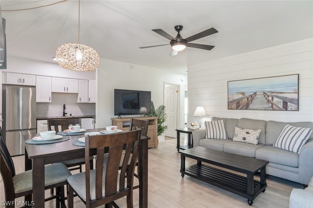 interior space featuring sink, light hardwood / wood-style floors, and ceiling fan with notable chandelier