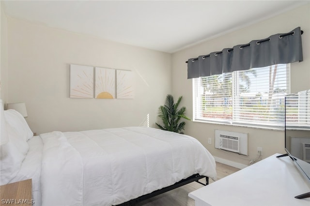 bedroom featuring hardwood / wood-style floors and a wall mounted AC