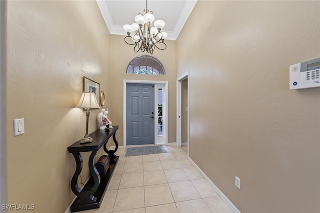 tiled foyer with a high ceiling, an inviting chandelier, and crown molding