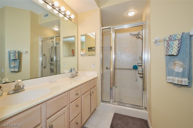 bathroom featuring dual sinks, a shower with shower door, oversized vanity, and tile flooring