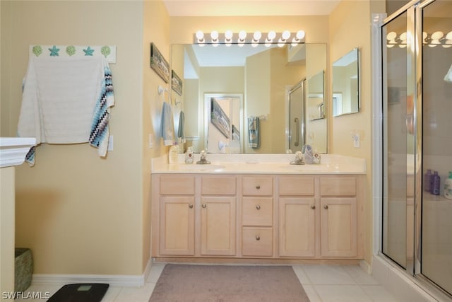 bathroom with a shower with shower door, double vanity, and tile floors