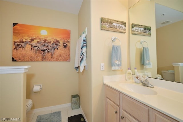 bathroom featuring tile floors, toilet, and vanity with extensive cabinet space