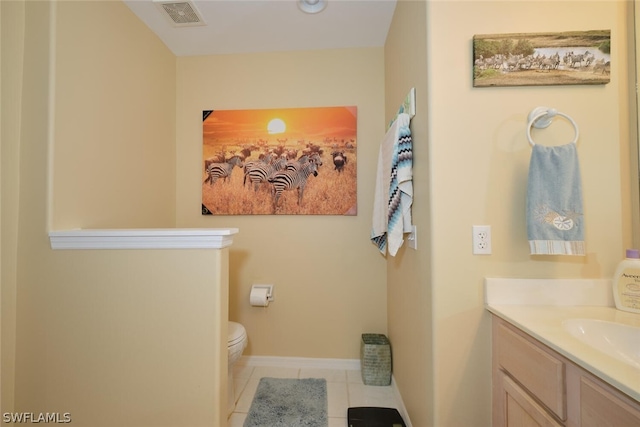 bathroom featuring tile flooring, vanity, and toilet