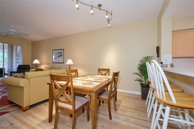 dining area with light hardwood / wood-style floors, ceiling fan, and track lighting