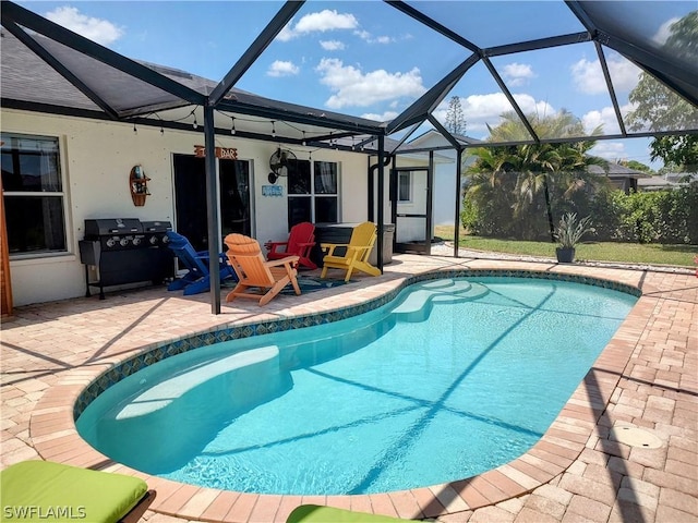 view of pool with a lanai, area for grilling, and a patio area