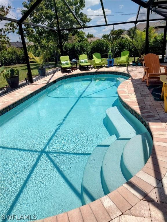 view of swimming pool featuring a lanai and a patio