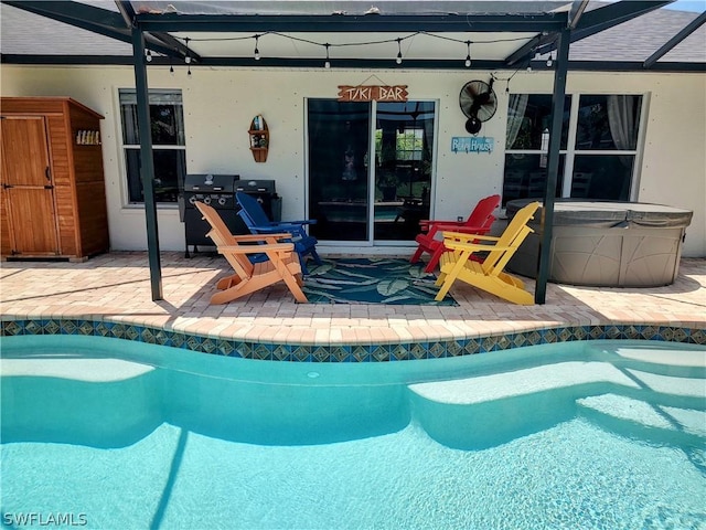 view of swimming pool with a hot tub, a patio, and a lanai