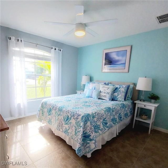 bedroom with ceiling fan and tile patterned floors