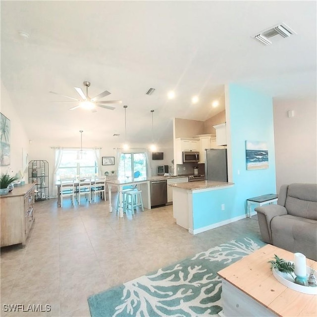 living room with vaulted ceiling, sink, and ceiling fan