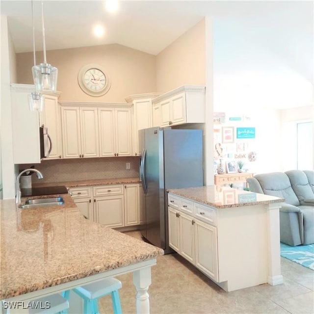 kitchen featuring sink, decorative light fixtures, kitchen peninsula, stainless steel appliances, and light stone countertops