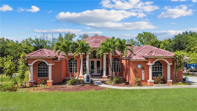 mediterranean / spanish-style home featuring a front yard