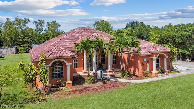 mediterranean / spanish-style home featuring a front yard