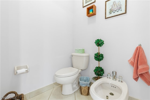 bathroom featuring a bidet, toilet, and tile floors