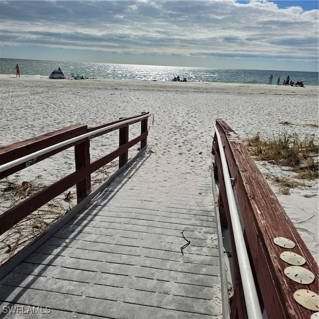 dock area with a water view and a view of the beach