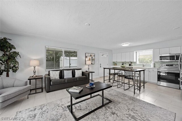 tiled living room featuring a textured ceiling